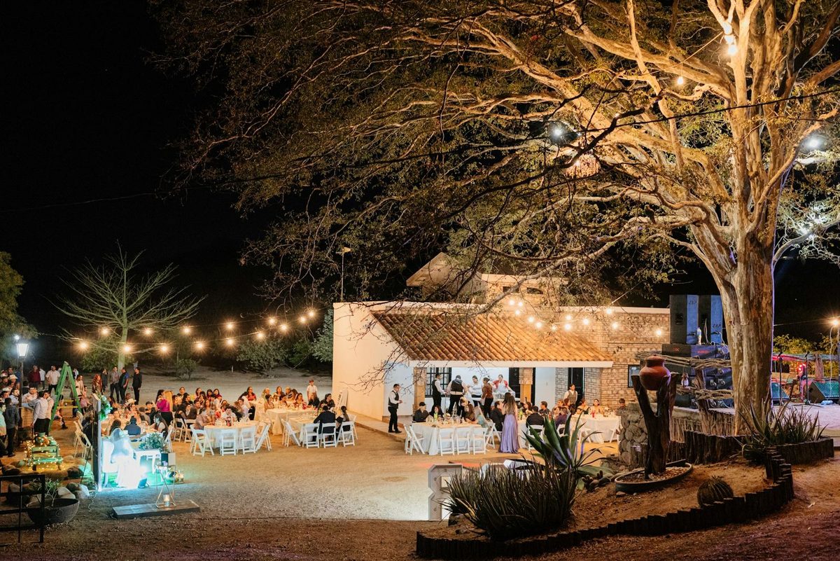 An outdoor evening reception lit with string lights